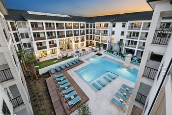 Resort inspired pool with sun shelf and poolside cabanas